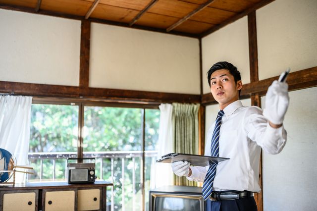 室内で現地見積もりをしている男性